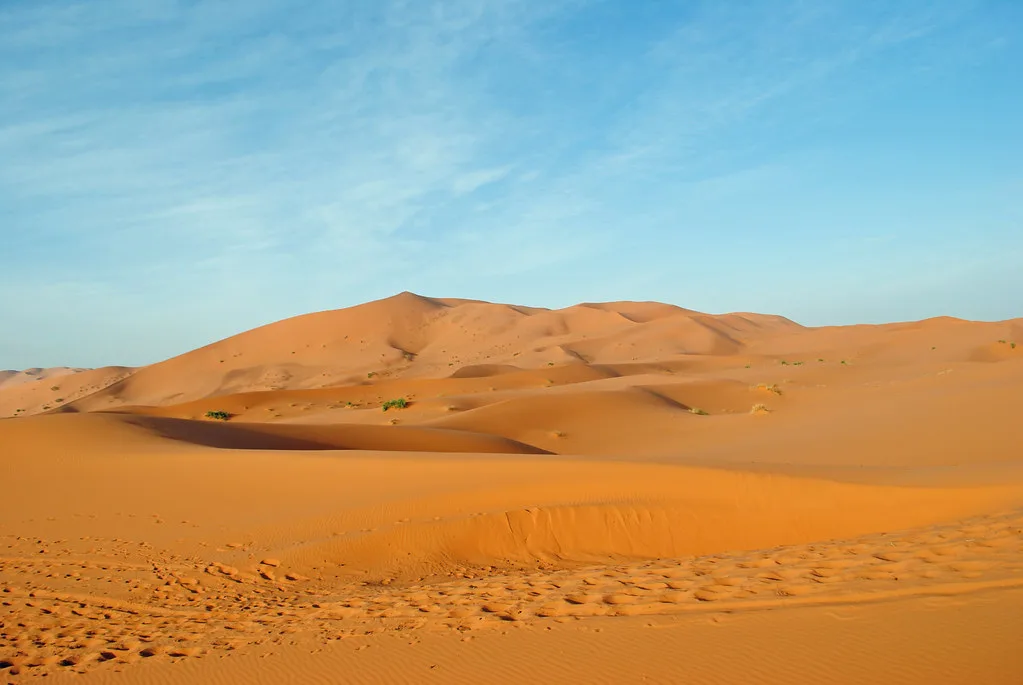 Viajeros disfrutando de un paseo en camello durante el mejor tour desierto marrakech 3 dias en Erg Chebbi Viajeros disfrutando de un paseo en camello durante el mejor tour desierto marrakech 3 dias en Erg Chebbi