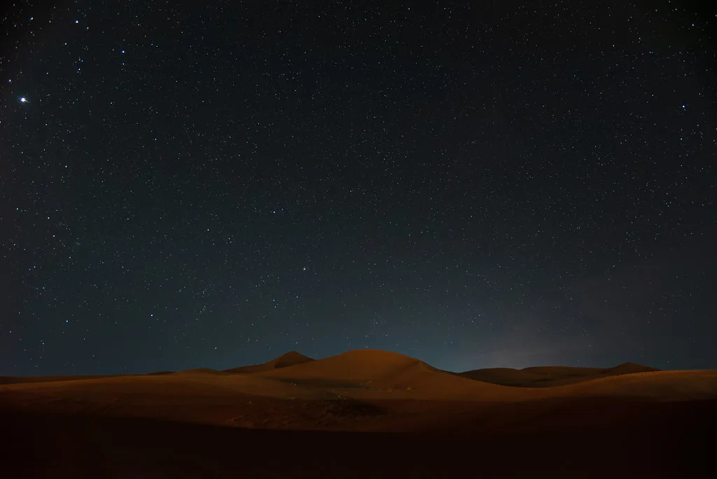 Acogedor campamento bereber en el desierto iluminado bajo un cielo estrellado brillante en Marruecos Acogedor campamento bereber en el desierto iluminado bajo un cielo estrellado brillante en Marruecos